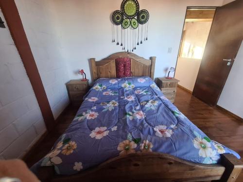 a bedroom with a bed with a blue comforter at Alojamiento Quincho Pascual in Las Compuertas