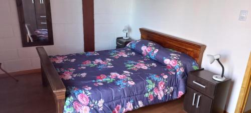 a bedroom with a bed with a purple comforter at Alojamiento Quincho Pascual in Las Compuertas
