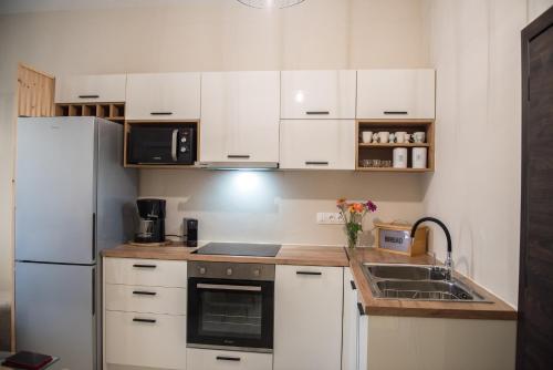 a kitchen with white cabinets and a white refrigerator at Boboli Holiday House Acharavi Corfu in Acharavi