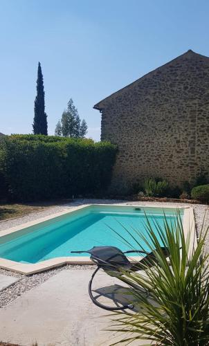 - une piscine avec une chaise à côté d'une maison dans l'établissement La Maison Ocre, à Rochegude