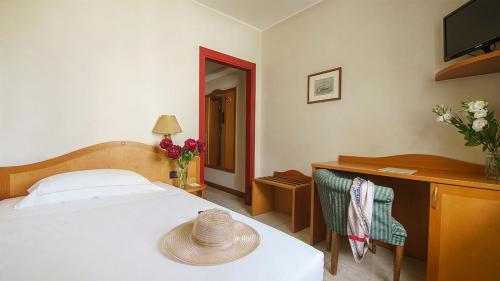 a bedroom with a bed and a desk with a hat on it at Hotel Villa Zoia in Boltiere