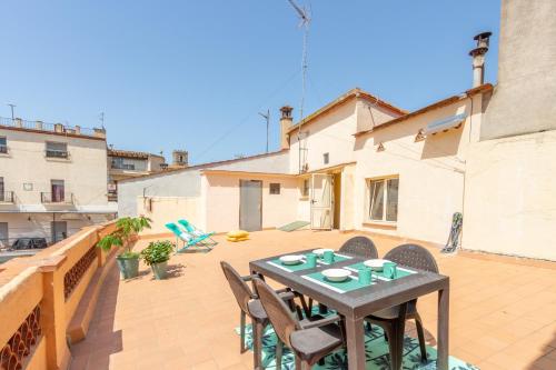 a patio with a table and chairs on a balcony at Costa Brava acollidor apartament amb gran terrassa per a 3 persones in Castelló d'Empúries