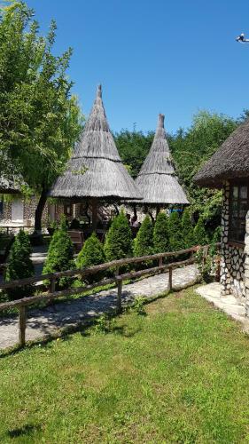 a group of gazebos with grass roofs at Pensiunea Iubire de Delta " La Traian " in Murighiol