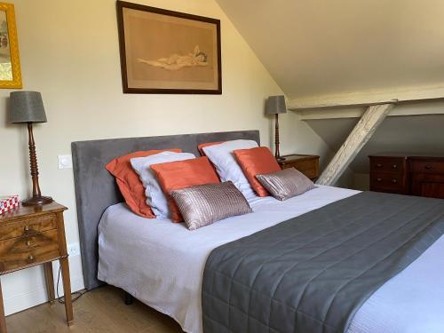 um quarto com uma cama grande e almofadas laranja em La Grange aux portes du Touquet, 1 ou 2 ch, terrasse, jardin, parking em Cucq