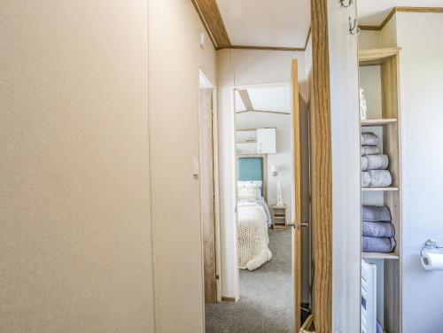 a hallway with a room with a bed and a door at Moondunes - Pwllheli in Pwllheli