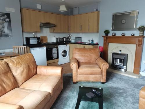 a living room with a couch and chairs and a fireplace at Gwynedd House Flat 1 in Pentraeth