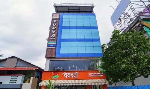 Un palazzo alto con un cartello sul lato. di Treebo Trend Surya Comforts 200 Mtrs From Kolhapur Railway Station a Kolhapur