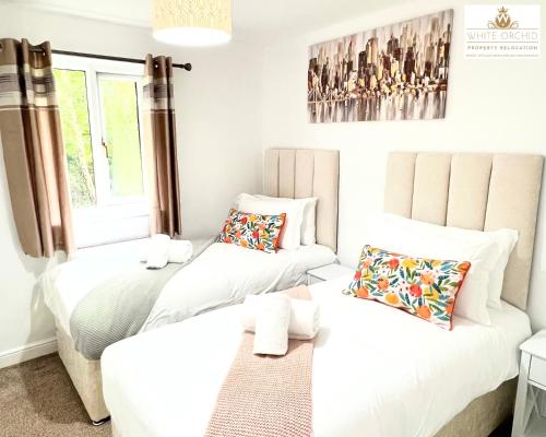 a bedroom with two beds and a couch at Contractors 2 Bed Apartment in Stevenage near Asda By White Orchid Property Relocation Leisure & Business in Stevenage