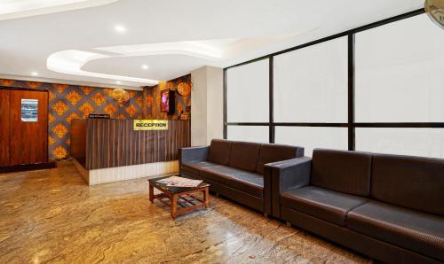 a living room with a couch and a table at Treebo Surya Comforts, 200 Mtrs From Kolhapur Railway Station in Kolhapur