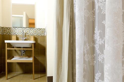 a bathroom with a sink and a shower curtain at Villa Polara in Modica