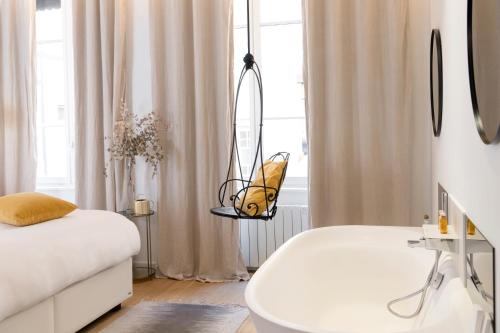a bedroom with a white bed and a mirror at MiHotel Charité in Lyon
