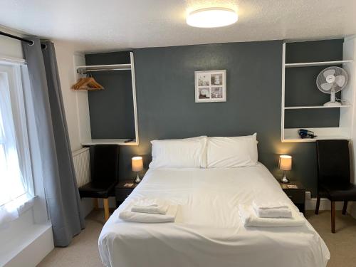 a bedroom with a white bed with two towels on it at The Royal Clarence Hotel (on the Seafront) in Burnham on Sea