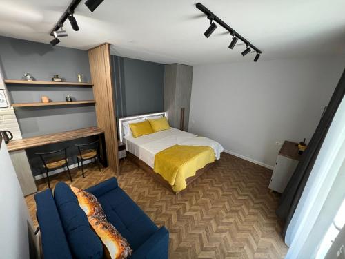 1 dormitorio con 1 cama y 1 sofá azul en Florent's Superb Studio, free parking & garden!!, en Tirana