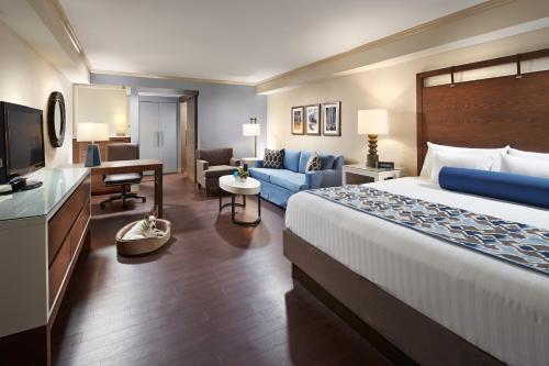 a hotel room with a bed and a living room at The Anza-a Calabasas Hotel in Calabasas