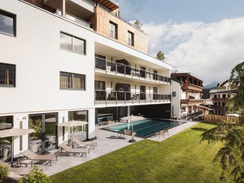 einen Blick nach außen auf ein Gebäude mit einem Pool in der Unterkunft alpina&more APARTMENTS I ZIMMER in Serfaus