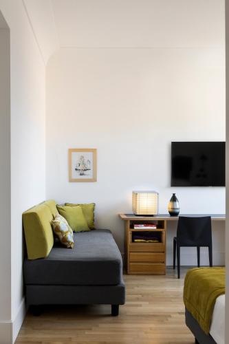 a living room with a couch and a desk at Hotel Plaza Opéra in Palermo