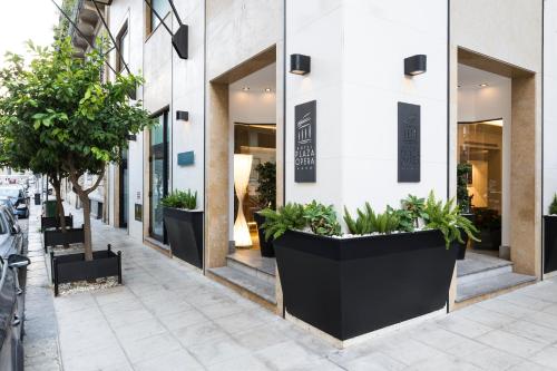 a building with large black planters on the sidewalk at Hotel Plaza Opéra in Palermo