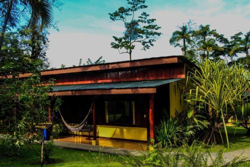 a small house with a hammock in front of it at Catarata Eco Lodge in Fortuna