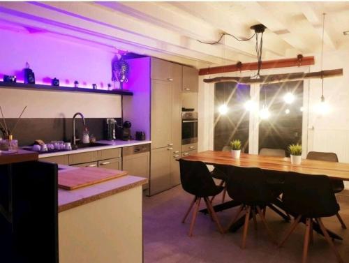 cocina con mesa de comedor e iluminación púrpura en Beautiful Duplex in the center of Brussels, en Bruselas