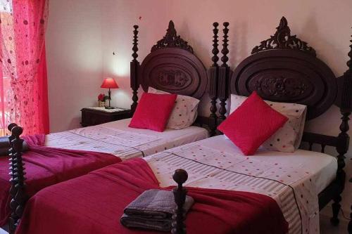 Ria Formosa Pineview في فارو: غرفة نوم بسريرين ومخدات حمراء