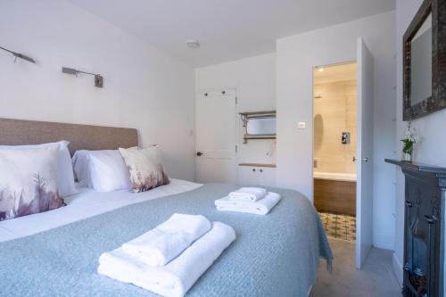 a bedroom with a bed with towels on it at Nutshell Cottage in Lymington