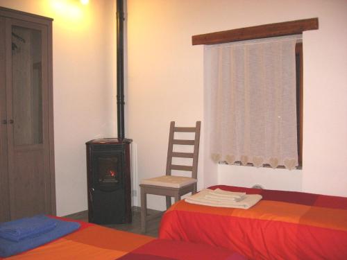 a bedroom with a stove and a bed and a chair at Torrente Rosandra in San Dorligo della Valle