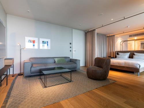 a living room with a couch and a bed at b'mine Hotel Frankfurt Airport in Frankfurt/Main