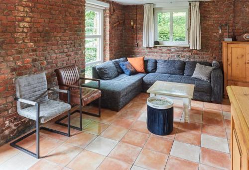 a living room with a couch and chairs and a brick wall at Mooiste plek heuvelland in Zuid-Limburg-De Wijngaard in Vijlen