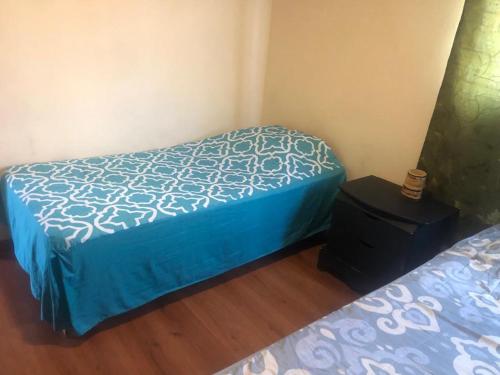 a small bedroom with a bed and a night stand at Espacios de Pando in Puebla