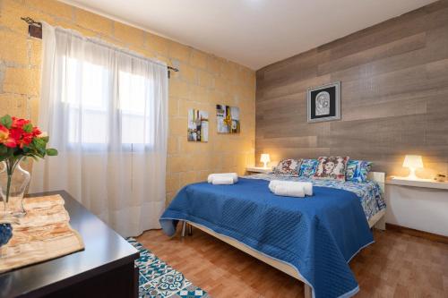 una camera con un letto blu e una finestra di Villa Ina a Cinisi