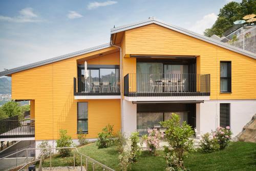 a yellow house with a balcony at Reka-Feriendorf Albonago in Viganello