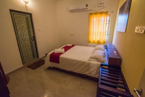 a small bedroom with a bed and a window at Cheerful 2-bedroom near Auro Beach in Kālapettai