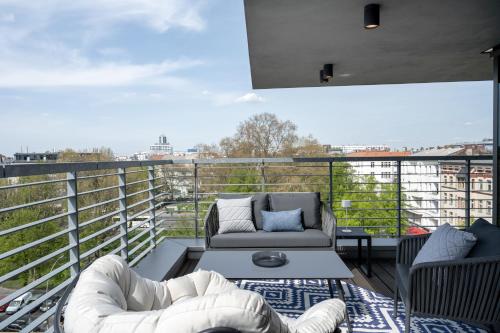 a balcony with a couch and chairs on a roof at June Six Hotel Berlin City West in Berlin