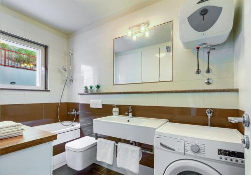 a bathroom with a washing machine and a sink at Villa Desideria in Solin