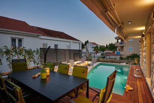 a patio with a table and chairs next to a swimming pool at Villa Nika with private heated pool in Slano