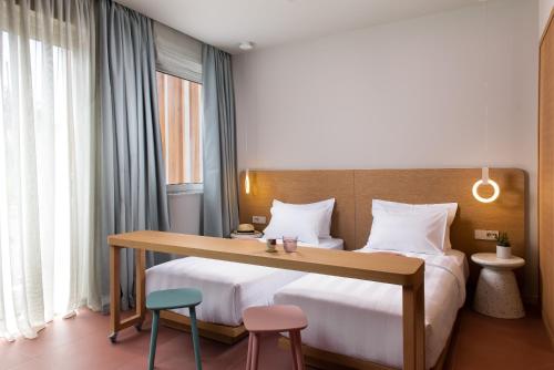 sypialnia z dużym łóżkiem, biurkiem i dwoma krzesłami w obiekcie Alkima Athens Hotel w Atenach