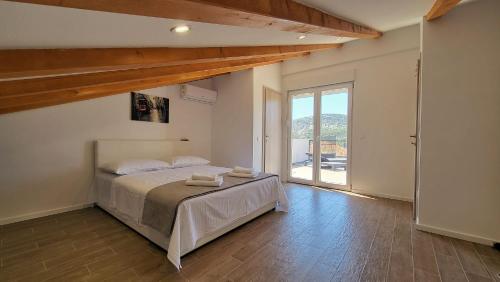 a bedroom with a bed and a large window at Villa Accordo in Vinišće