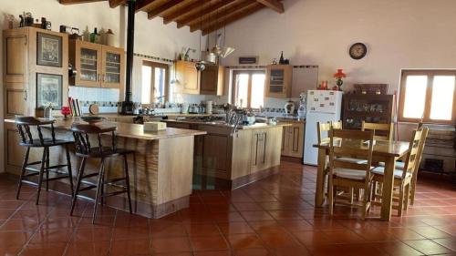 a kitchen with a table and some chairs and a counter at Monte da Bela Vista - Luxury Villa 10 mins from best beaches in Portugal in Pedreneiras