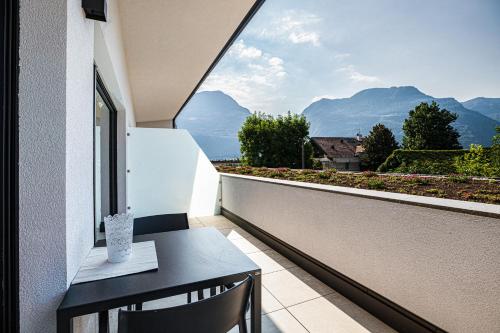a balcony with a table and a view of mountains at Apartments Curti - Abendrot in Laives