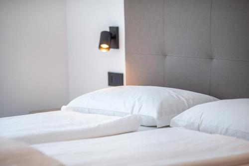 two white beds with white pillows in a bedroom at Apartments Curti - Abendrot in Laives
