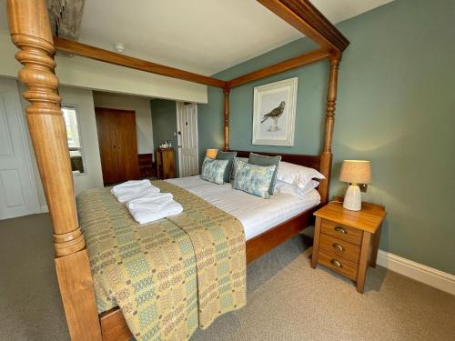 a bedroom with a canopy bed and a night stand at The Ship in Parkgate