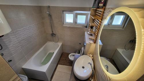 a bathroom with a tub and a sink and a mirror at Villa Accordo in Vinišće