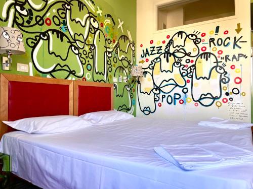 Postel nebo postele na pokoji v ubytování LH Hotel Arca Street Art