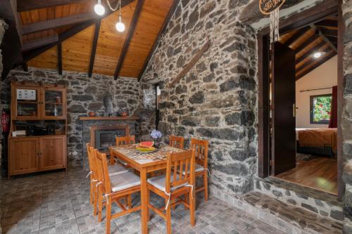 a stone walled dining room with a wooden table and chairs at Casa de Campo Arco de São Jorge by An Island Apart in Santana