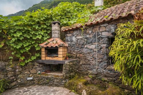 a stone building with a oven on the side of it at Casa de Campo Arco de São Jorge by An Island Apart in Santana