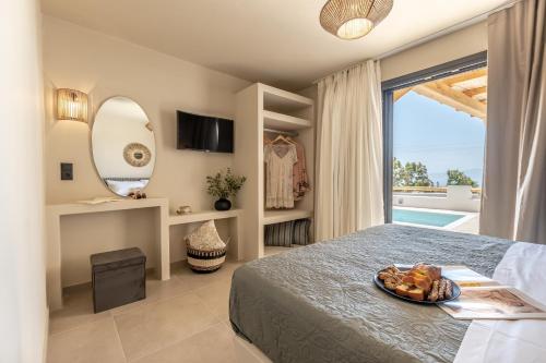 a bedroom with a bed with a tray of food on it at Golden Sand Villas with Private Pool in Vívlos