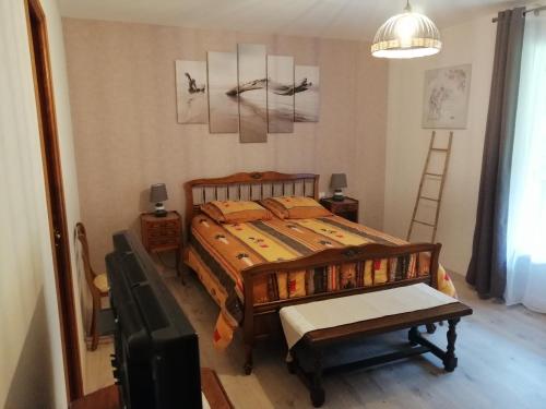ein Schlafzimmer mit einem Bett und einem TV sowie ein Zimmer mit einem Bett in der Unterkunft A LA JOIE DE VIVRE Chez l'habitant in Banat