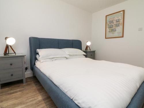 1 dormitorio con 1 cama con 2 mesitas de noche y 2 lámparas en 65 Channel View, en Ilfracombe