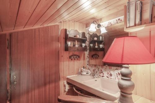 een badkamer met een wastafel en een rode lamp bij Tournette Montagnes et Lacs in Saint-Jean-de-Sixt