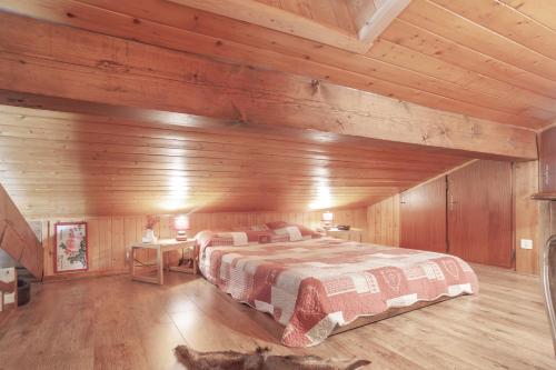 een slaapkamer met een bed in een houten hut bij Tournette Montagnes et Lacs in Saint-Jean-de-Sixt